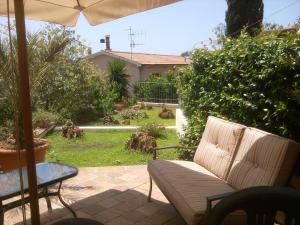 a patio with a couch and a table and an umbrella at Villarosamaratea in Maratea