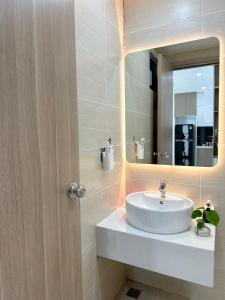 une salle de bain avec un lavabo et un miroir dans l'établissement Hue Charm Apartment -Nera Garden, à Thôn Văn Dương