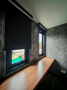 a room with a window and a wooden table at Lay Sea and Beach Hotel in Phetchaburi