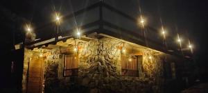 a stone building with lights on it at night at Nasaka jacala in Cuetzalán del Progreso