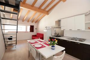 cocina y comedor con mesa blanca y sillas en Appartamenti Segantini en Arco