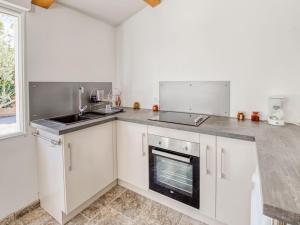 Una cocina con gabinetes blancos, un fregadero y una estufa. en Holiday Home La Seyne near Beaches, en La Seyne-sur-Mer 32 fotos más