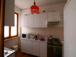 Una cocina con gabinetes blancos y un horno de estufa. en Holiday home in Magione above lake Trasimeno, en Magione