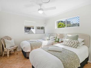 a bedroom with two beds and a chair at Sunrise Cove 17 in Kingscliff