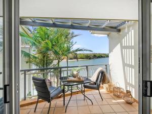 a balcony with a table and chairs and a view of the water at Sunrise Cove 17 in Kingscliff