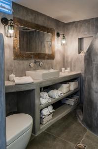 a bathroom with a sink and a toilet and a mirror at Aerides Mandrakia Milos in Mandrakia