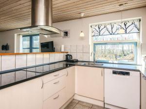 a kitchen with white cabinets and a sink and a window at 12 person holiday home in Hojslev-By Traum in Bøstrup