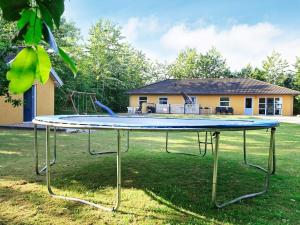 Un trampolín en un patio frente a una casa. en 12 person holiday home in Hojslev-By Traum, en Bøstrup