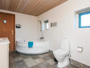 Un baño con bañera blanca y un inodoro. en 12 person holiday home in Hojslev-By Traum, en Bøstrup