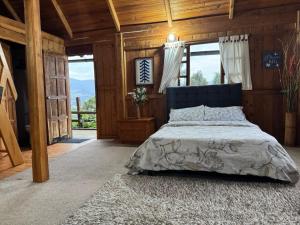 ein Schlafzimmer mit einem Bett in einem Zimmer mit Holzwänden in der Unterkunft Complejo Ecoturístico El Refugio in Subachoque