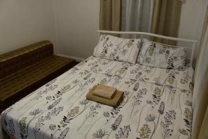 a bed with a white comforter with a purse on it at Max - Relax Staycation in Davao City