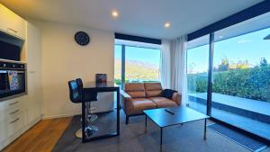 una sala de estar con un sofá y una mesa en Lakevista Haven -- Spa Pool - Hot Tub with Views, en Queenstown