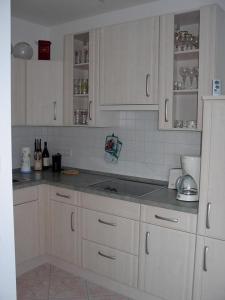 eine Küche mit weißen Schränken und grauen Arbeitsplatten in der Unterkunft MaRa-Ferienhaus in Dranske