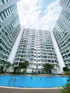 un grand immeuble avec une piscine en face de celui-ci dans l'établissement Hue Charm Apartment -Nera Garden, à Thôn Văn Dương