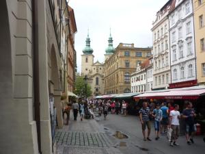 a crowd of people walking down a street with buildings at Apartment Havelska 10 in Prague