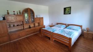 a bedroom with two beds and a wooden cabinet at domek w pobliżu jeziora in Czarnówka