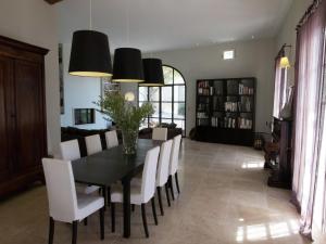 een eetkamer met een zwarte tafel en witte stoelen bij Holiday Home in Hérault with Pool in Campagnan