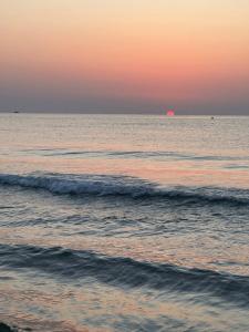 a sunset over the ocean with waves in the water at First Floor Casa Privee - Two bed Beach Terrace & Balconies in Puerto de Sagunto