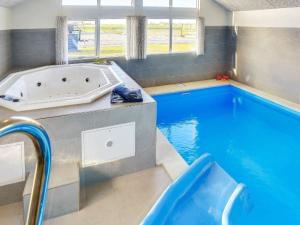 a large swimming pool with a tub in a house at 5 star holiday home in Bogense in Bogense