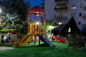 einen Spielplatz mit Rutsche auf einem grünen Rasen in der Unterkunft Orchidea Hotel in Tirana