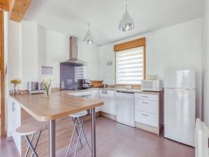 una cucina con un tavolo di legno e un frigorifero di Pleasant Cottage in Challerange a Challerange