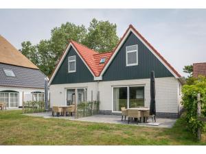 德科克斯多普Bungalow on Texel with a spacious terrace的一座带桌椅的绿色屋顶房子