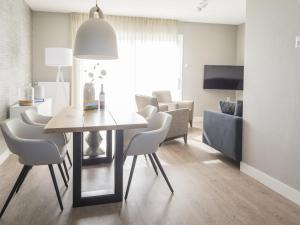デ・カクスドルプにあるBungalow on Texel with a spacious terraceのリビングルーム(ダイニングテーブル、椅子付)
