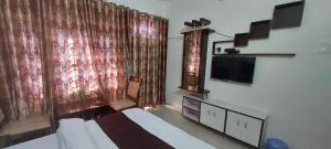 a bedroom with a bed and a large window at Govind Bhanadhar in Rudraprayāg