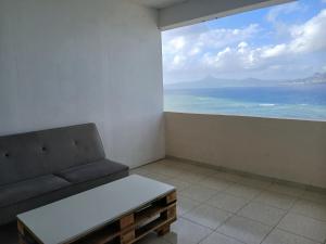 ein Zimmer mit Sofa und Meerblick in der Unterkunft résidence IDIMAH in Sada
