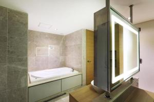 a bathroom with a bath tub and a sink at Business Design Hotel LUV in Incheon +244 photos