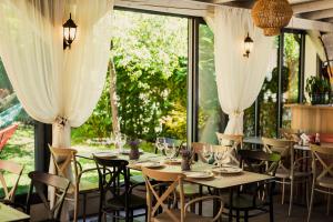 a dining room with tables and chairs and windows at Vila Sunce Village Resort Konjic in Konjic +20 photos