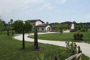 una carretera que conduce a una casa con palmeras en Corte di Tosina, en Monzambano