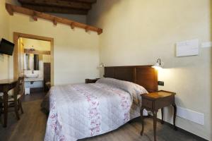 una camera da letto con un letto, una scrivania e un lavandino di Corte di Tosina a Monzambano
