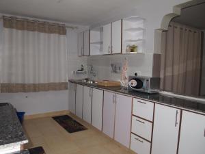 a kitchen with white cabinets and a microwave at Vanna Nest in Maragoli