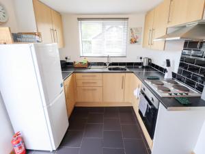 a kitchen with a white refrigerator and a sink at Angel's Retreat in Alford