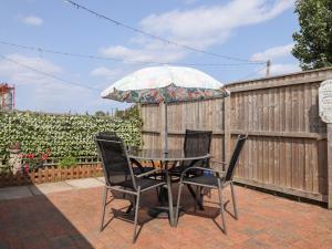 a table with chairs and an umbrella on a patio at Angel's Retreat in Alford