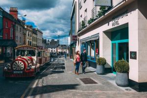a man and woman walking down a street with a train at Kilkenny Pembroke Hotel in Kilkenny
