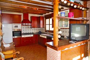 a kitchen with red cabinets and a tv in it at Casa Icas in Cónchar
