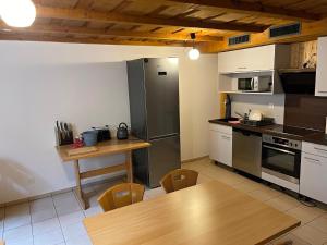 a kitchen with a wooden table and a counter top at Pension Balm in Meiringen