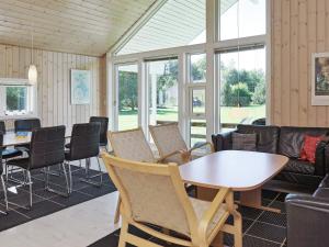 ein Wohnzimmer mit Tisch und Stühlen in der Unterkunft Holiday Home with Sauna by Beach in Vester Sømarken