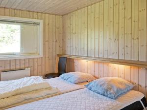 ein Schlafzimmer mit zwei Betten und einem Fenster in der Unterkunft Holiday Home with Sauna by Beach in Vester Sømarken