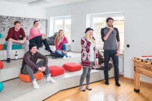 a group of people sitting on a couch with a microphone at Oberstdorf Hostel in Oberstdorf