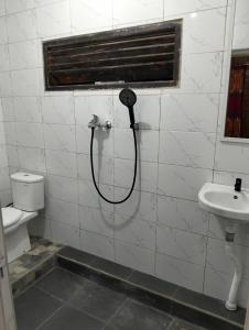 a shower in a bathroom with a phone on the wall at Nataqueen Bungalows in Tetebatu