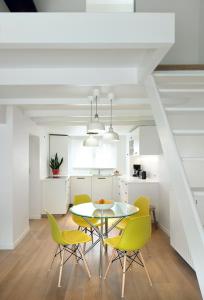 a kitchen and dining room with a table and yellow chairs at Centreflat A26 in Ghent