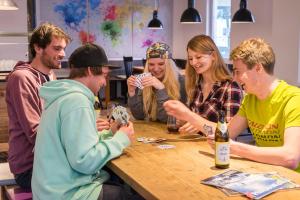 a group of people sitting around a table playing cards at Oberstdorf Hostel in Oberstdorf
