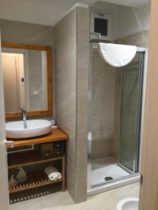 a bathroom with a shower and a sink and a mirror at Apartments 3.0 in Torre Lapillo +20 photos