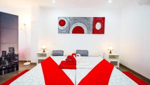 カン・ピカフォルトにあるCan Picafort Loftのベッドルーム1室(赤と白のベッド1台、絵画付)