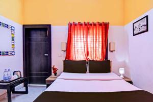 Un dormitorio con una cama con una cortina roja. en Hotel O Modern Stay Near ITER, en Bhubaneshwar