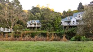 deux maisons sur une colline à côté d'une rivière dans l'établissement Little Plum Cottage, à Apollo Bay