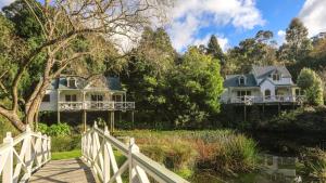 une maison avec une clôture blanche et un pont dans l'établissement Little Plum Cottage, à Apollo Bay 10 autres photos